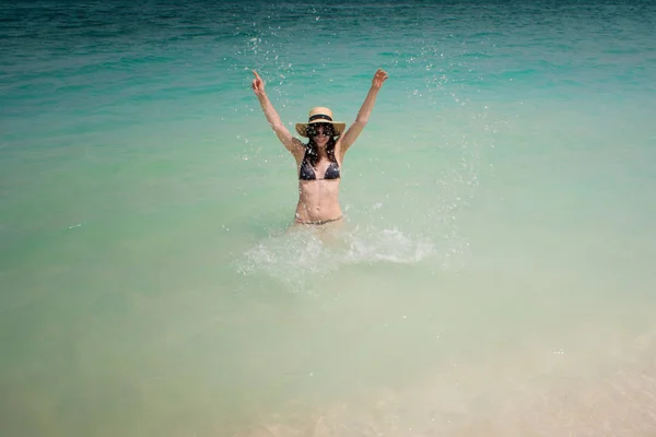 Happy young woman swimming in the azure sea. Funny girl in straw hat — Stock Photo, Image