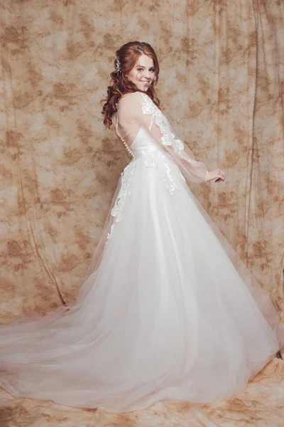 Mooie en romantische bruid in trouwjurk met lange mouwen. Jonge roodharige vrouw in trouwjurk — Stockfoto