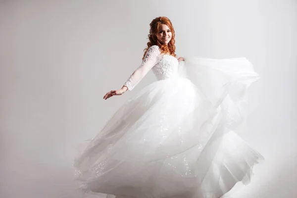 Lovely young woman bride in a lavish wedding dress. Light background. — Stock Photo, Image