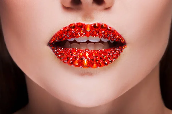 Labios rojos cubiertos de pedrería. Hermosa mujer con lápiz labial rojo en los labios — Foto de Stock