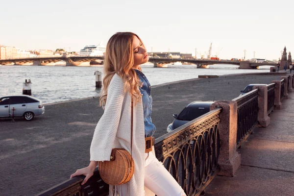 Porträt einer lächelnden Frau in einer weißen Strickjacke. lachendes Mädchen auf dem Hintergrund der Straße — Stockfoto