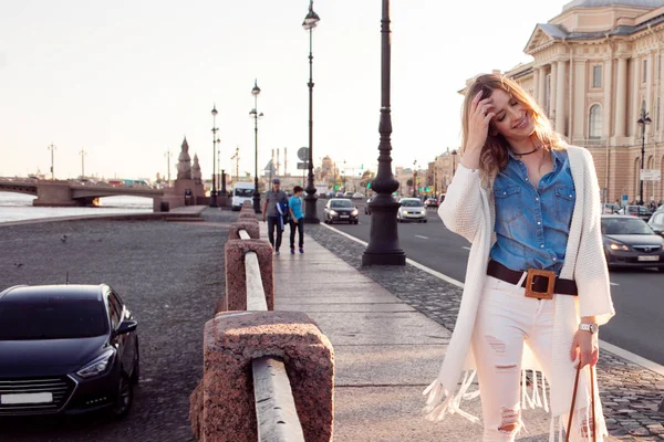 Porträt einer lächelnden Frau in einer weißen Strickjacke. lachendes Mädchen auf dem Hintergrund der Straße — Stockfoto