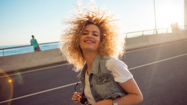 Jovem mulher bonita e alegre com cabelo exuberante, ao ar livre — Fotografia de Stock