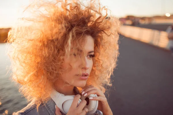 Chica de moda con auriculares grandes en un paseo por la ciudad, de cerca — Foto de Stock