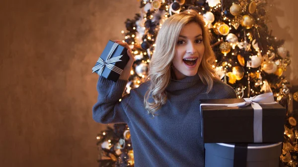 Linda jovem loira com caixas de presente sob a árvore de Natal — Fotografia de Stock