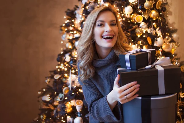 Linda jovem loira com caixas de presente sob a árvore de Natal — Fotografia de Stock