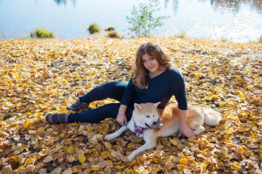 Genç kadın bir yürüyüş ile onun köpek doğurmak Akita Inu