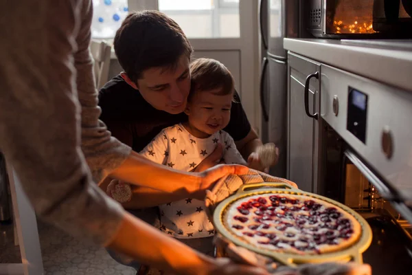 Familia multiétnica joven haciendo un pastel juntos — Foto de Stock