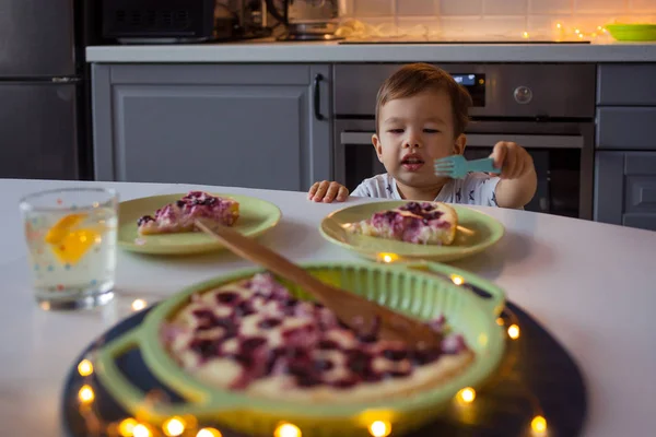 Happy kid reaching for homemade cake. Home kitchen