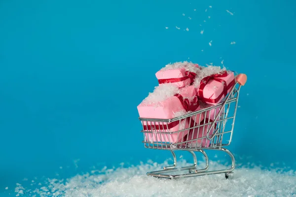 Shopping natalizio in loco. Cercare regali di Natale per tutta la famiglia, concetto. carrello è pieno di scatole regalo — Foto Stock