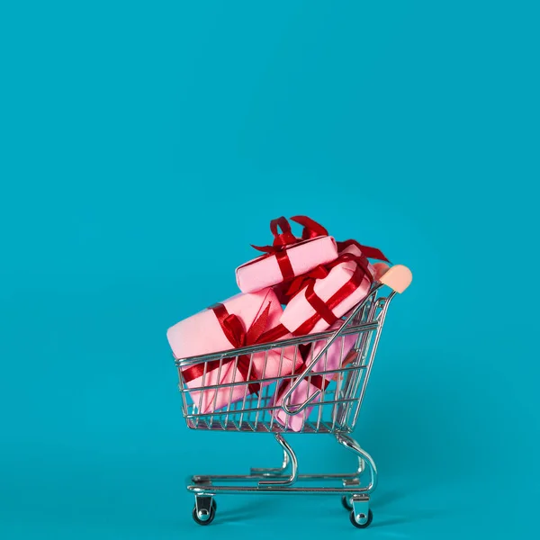 Caixas de presente rosa no carrinho de compras. Vendas de férias, conceito . — Fotografia de Stock