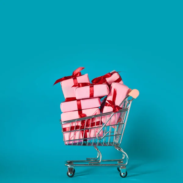 Caixas de presente rosa no carrinho de compras. Vendas de férias, conceito . — Fotografia de Stock