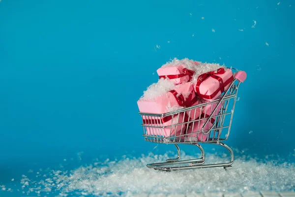 Vendas de Natal. Comprar presentes para o ano novo, o conceito. O carrinho de compras está cheio de caixas de presente — Fotografia de Stock