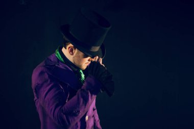 Şovmen şapka dokunur. Genç erkek şovmen, sunum veya sahne alanı'nda aktör.