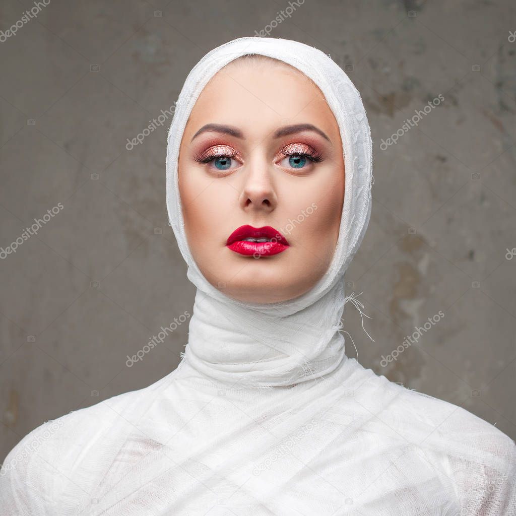 Glamorous mummy. Portrait of a young beautiful woman in bandages all over her body