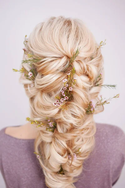 Visão traseira de um penteado elegante na moda, entrelaçando cachos e decoração com pétalas de flores — Fotografia de Stock