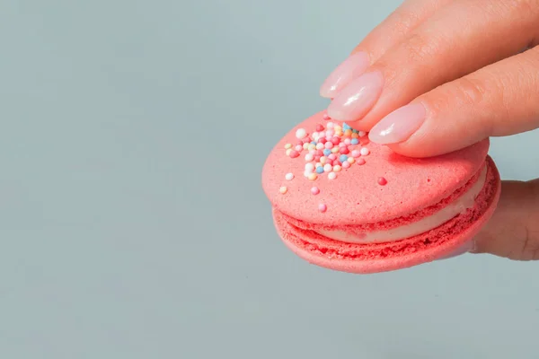 Take it Beautiful bright macaroons. Sweet almond French dessert. Woman\'s hand takes one cookie