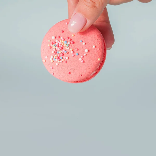 Prendilo Bellissimi amaretti luminosi. Dolce dessert francese alle mandorle. La mano della donna prende un biscotto — Foto Stock