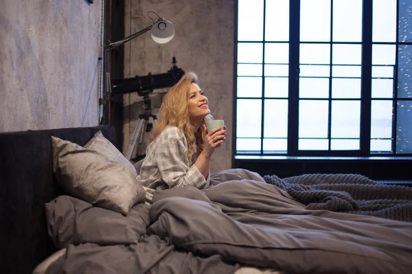 Uppfriskande doft av kaffe, hjälper till att vakna upp på morgonen. Charmig ung kvinna i pyjamas — Stockfoto