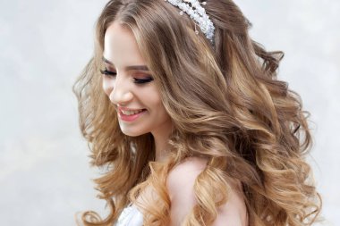 Lüks saç modeli ile büyüleyici genç gelin. Gelinlik güzel kadın. Kabarık kıvırcık saç modeli.