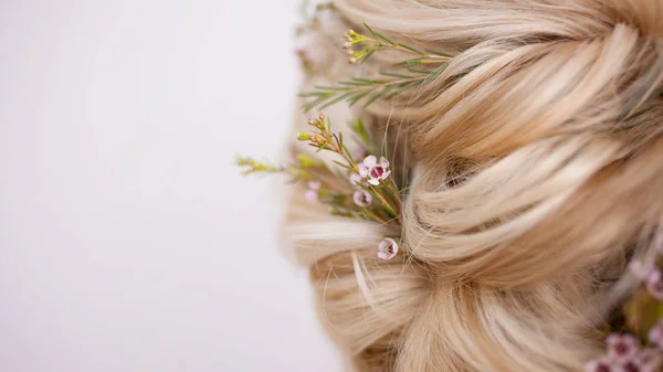 Close-up de penteados com fios de tecelagem decorados com pequenas flores . — Fotografia de Stock