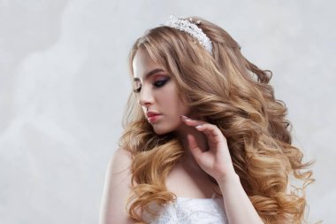 Lüks saç modeli ile büyüleyici genç gelin. Gelinlik güzel kadın. Kabarık kıvırcık saç modeli.