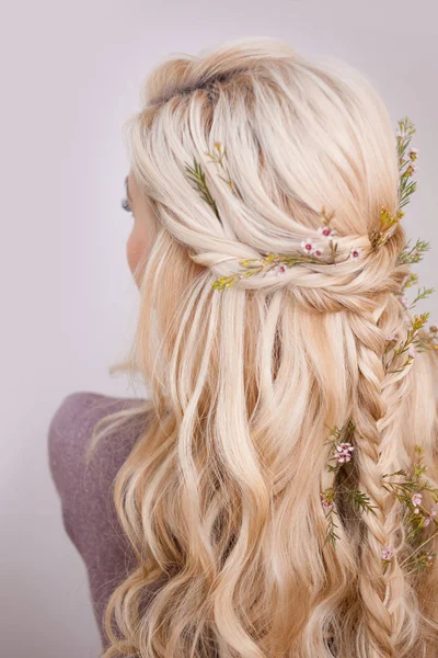 Visão traseira de um penteado elegante na moda, entrelaçando cachos e decoração com pétalas de flores — Fotografia de Stock