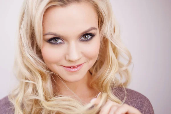 Portrait of beautiful blonde young woman with long luxurious curls. — Stock Photo, Image