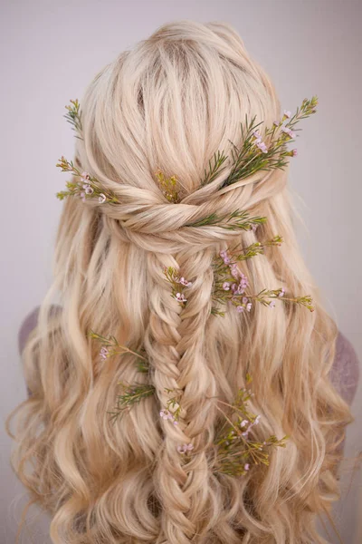 Visão traseira de um penteado elegante na moda, entrelaçando cachos e decoração com pétalas de flores — Fotografia de Stock