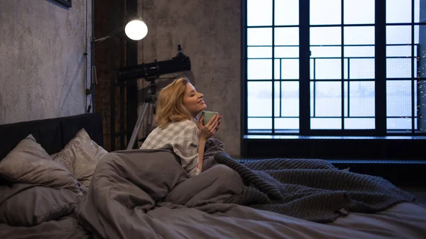 Kız sabah erken daire ve içecekler kahvesini yatakta uyandım — Stok fotoğraf