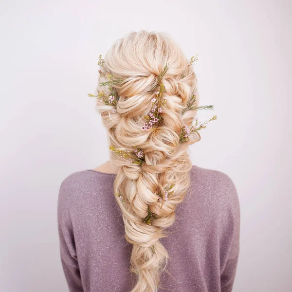 Vista posterior de un elegante peinado de moda, entrelazando rizos y decorando con pétalos de flores —  Fotos de Stock