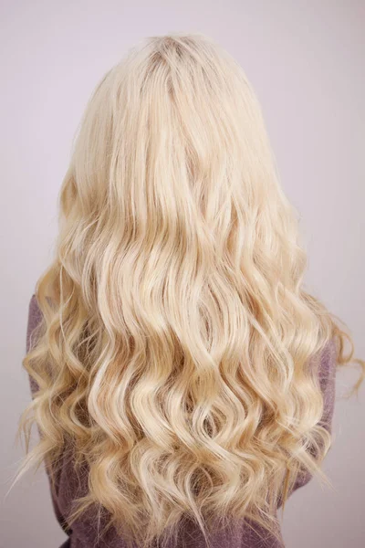 Zadní pohled na blondýnka s dlouhou luxusní kadeře. — Stock fotografie