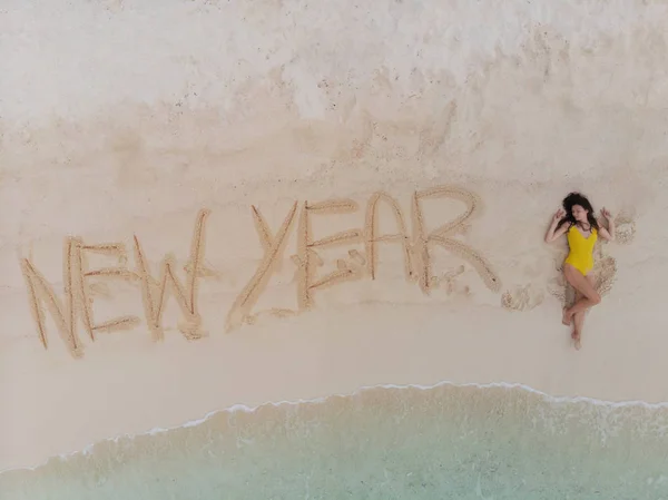 Un nuevo año en el sur, el mar. Surf marino. Inscripción en la arena, celebrar el año nuevo en los trópicos. Vacaciones de año nuevo — Foto de Stock