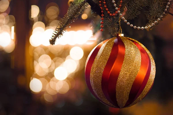 Великий червоний золотий м'яч на передньому плані. Різдвяний фон, різдвяні прикраси та гірлянди — стокове фото