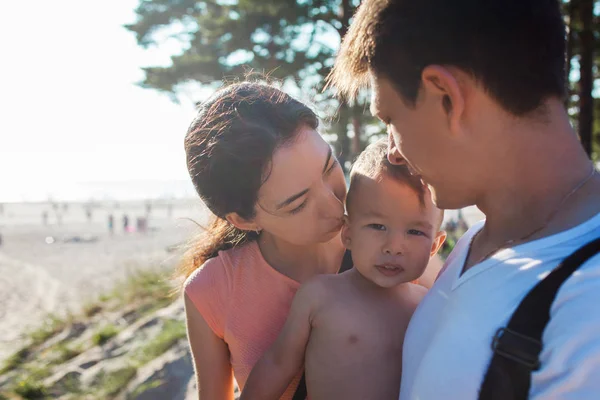Retrato de familia joven y feliz con un bebé encantador. Picnic en la playa — Foto de Stock