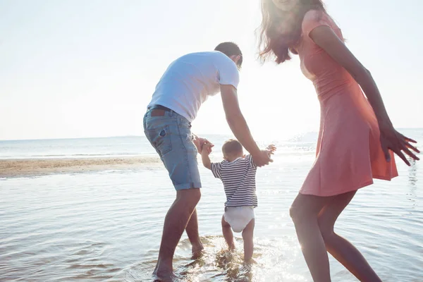 Mamma e papà insegnano al bambino a camminare — Foto Stock