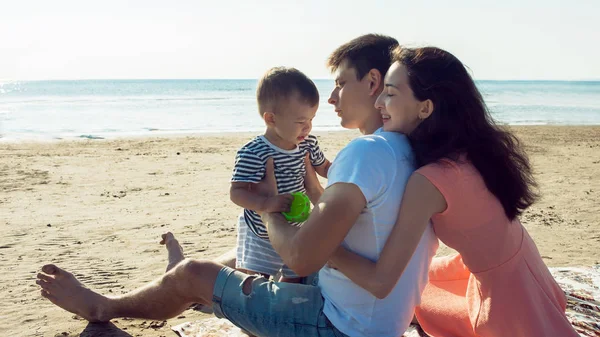 Cheerful multi ethnic family have a rest on a sea shore.