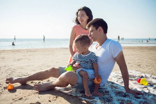 Cheerful multi ethnic family have a rest on a sea shore.