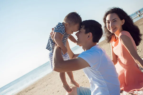 La famiglia multietnica allegra ha un riposo su una riva di mare . — Foto Stock