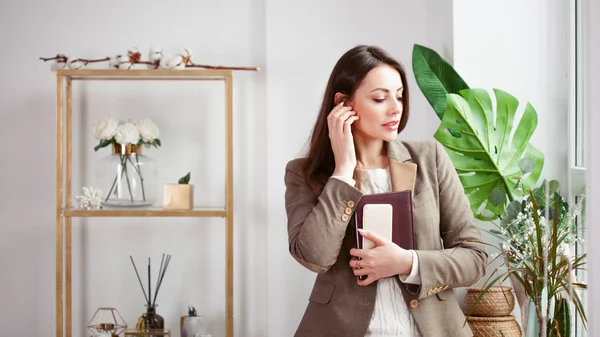 Jeune femme d'affaires au bureau contre la fenêtre, en utilisant le téléphone mobile — Photo