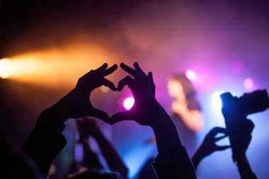 Concert in the club, the hands of the people in front of those lights. sign of the heart, 