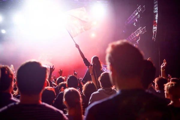 Rockkonsert, personer i salen på bakgrund av scenen och spotlights. — Stockfoto