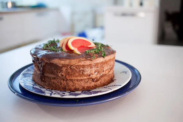 Chocolade cake met chocolade gegoten en versierd met grapefruit segmenten — Stockfoto