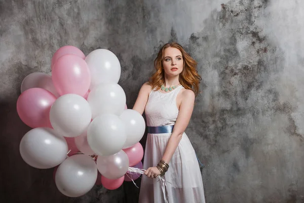 Rudowłosa piękność młoda kobieta w białej sukni, pęczkiem duże balony — Zdjęcie stockowe