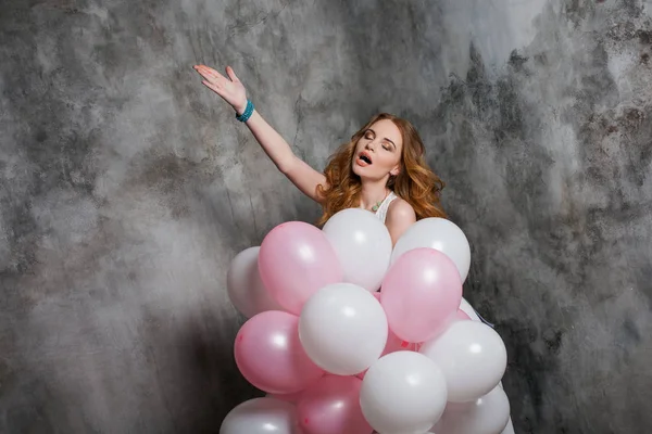 Uma jovem bonita com balão de ar envia um beijo de ar. Menina ruiva feliz e alegre . — Fotografia de Stock