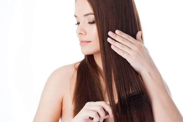 Cepíllese el pelo. Chica atractiva con el pelo largo. Retrato de una hermosa joven usando un peine — Foto de Stock