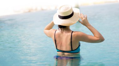 Havuzun içinde genç kadın arkadan görünüm.