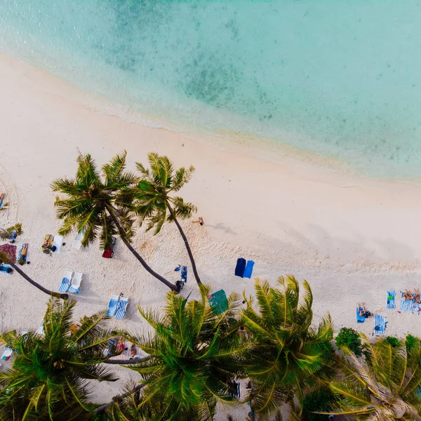 Hermosa playa con palmeras de arena blanca y mar azul claro. La gente toma el sol y nada — Foto de Stock