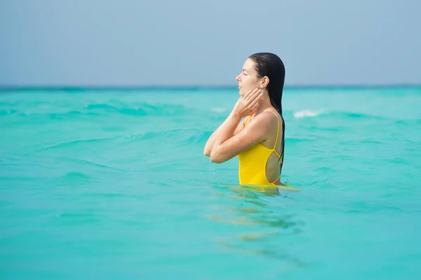 Young brunette woman in yellow one piece swimsuit. — Stock Photo, Image