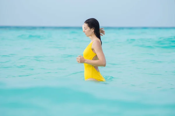 Jeune femme brune en maillot de bain une pièce jaune . — Photo